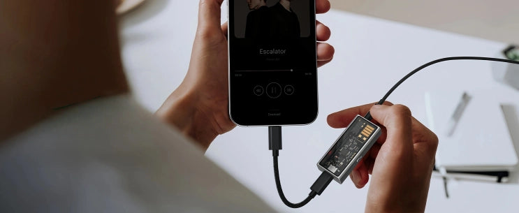 Questyle M15C portable DAC and headphone amplifier connected to a smartphone via Type-C cable, enhancing mobile music playback.